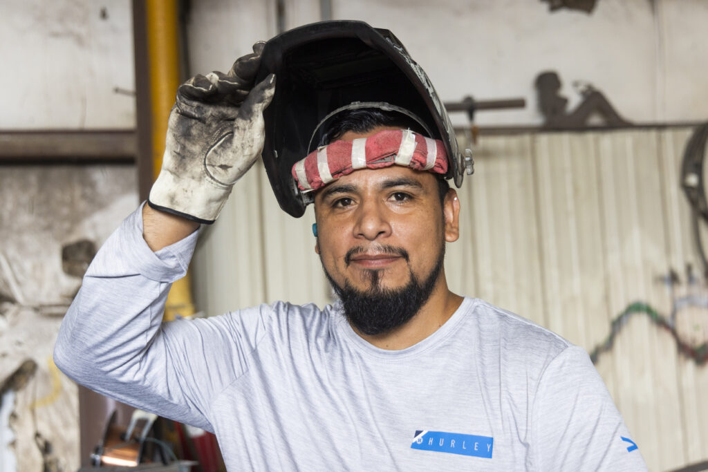 A man wearing a welding hat